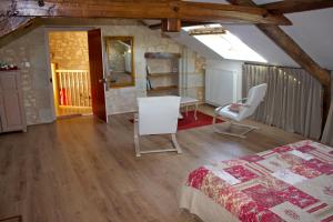 a bedroom with a bed and a table and chairs at La Troliere in Autry-Issards