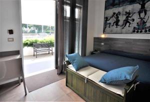 a bedroom with a bed with blue pillows and a window at Hotel Miramare Dipendenza in Pineto