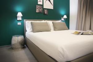 una camera da letto con un grande letto bianco con una parete verde di Affittacamere Bellavista a La Spezia