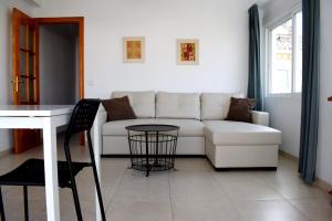 a living room with a white couch and a table at El Jardin BeNerja in Nerja