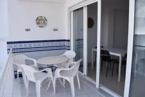 a white dining room with a table and chairs at El Jardin BeNerja in Nerja