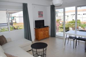 a living room with a white couch and a table at El Jardin BeNerja in Nerja