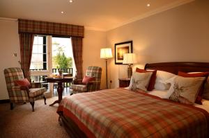 um quarto de hotel com uma cama, uma mesa e cadeiras em Macdonald Forest Hills Hotel & Spa em Aberfoyle