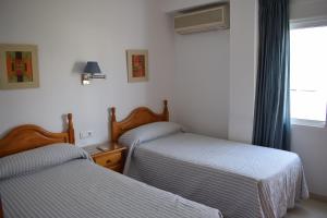 a bedroom with two beds and a window at El Jardin BeNerja in Nerja +37 photos