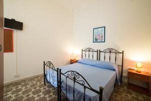 a bedroom with a bed with blue sheets and two lamps at Largo Madonna in Trapani