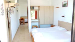 Habitación pequeña con 2 camas y pasillo en Kyriakos Studios, en Afantou
