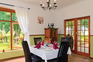 een eetkamer met een tafel met rode servetten bij Gondwana Kalahari Farmhouse in Stampriet