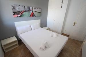 a white bed with slippers on it in a room at For a Stay Sant Jordi in Salou