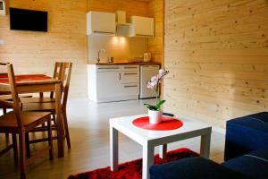 a living room with a table and a kitchen at Alkado Domki Jurata in Jurata