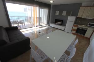 a kitchen and living room with a white table and chairs at For a Stay Sant Jordi in Salou