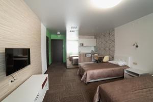 イジェフスクにあるHotel Cambridgeのベッド2台とテレビが備わるホテルルームです。