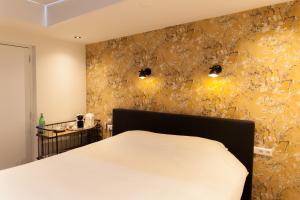 a bedroom with a white bed and a yellow wall at In het Assendorpje in Zwolle