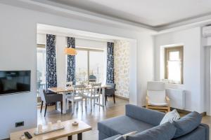 een woonkamer met een bank en een eetkamer bij White Villas in Karavomylos