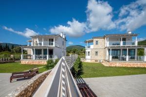 een groot huis met een hek ervoor bij White Villas in Karavomylos