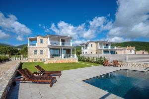 een villa met een zwembad en een huis bij White Villas in Karavomylos