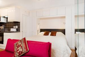 a bedroom with a bed and a red couch at Henley-on-Thames Studio Apartment in Henley on Thames