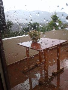 a table in the rain with a vase on it at Agioklima Traditional Cretan House in Petrokefalo