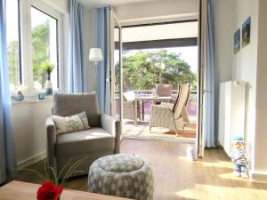 a living room with a couch and a chair at Ferienwohnung Sonnensegler in Juliusruh