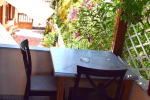 a table and chairs on a balcony with flowers at Krinelos Rooms in Skala Eresou