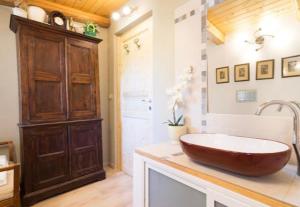 a bathroom with a wooden bowl sink on a counter at B&B Asparano Anita Open Space in Ognina