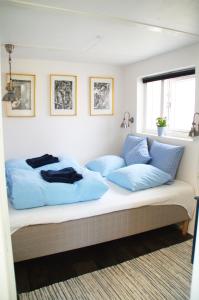 a bed with blue pillows on it in a room at Aarhus bugtens Perle in Malling