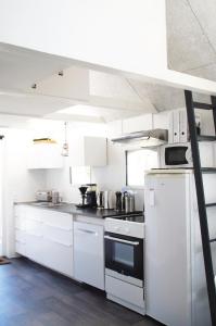 uma cozinha com armários brancos e um forno com placa de fogão em Aarhus bugtens Perle em Malling