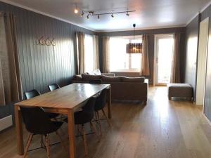 a living room with a wooden table and a couch at Skarsnuten Panorama 14 in Hemsedal