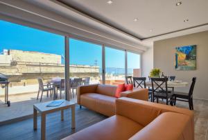 a living room with a couch and a table at Valletta Luxe 3-Bedroom Duplex Penthouse with Sea View Terrace and Jacuzzi in Valletta