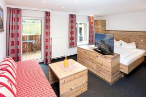 a hotel room with a bed and a table at Das Kleemanns - Nur für Erwachsene in Mittelberg