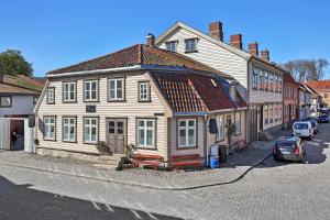 una vieja casa de madera al lado de una calle en Gamlebyen Hotell - Fredrikstad, en Fredrikstad