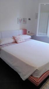 a large white bed in a room with a window at Charme e Relax in Levanto