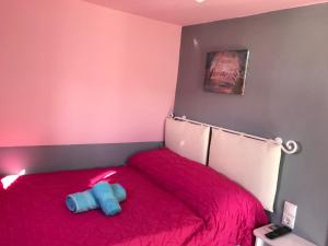 a bedroom with a red bed with a blue object on it at Fraskoula's Town in Mikonos