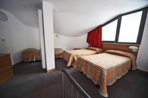 een hotelkamer met twee bedden en een raam bij Hotel Italia in Aprica