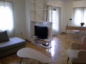 Apartment near the Beach في أثينا: غرفة معيشة مع تلفزيون بشاشة مسطحة على طاولة