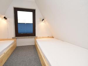 a small room with two beds and a window at Finnhütte Carolin in Gager