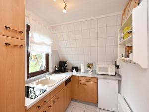 a small kitchen with a sink and a microwave at Finnhütte Carolin in Gager