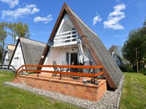 a house with a thatched roof with a porch at Finnhütte Carolin in Gager