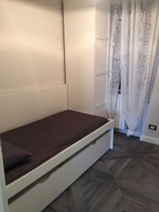 モンテジルヴァーノにあるResidenza Girasoleのカーテン付きの客室の小さなベッド1台分です。