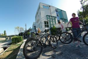 dwoje ludzi stojących z rowerami przed budynkiem w obiekcie Hotel Sv. Mihovil w mieście Trilj