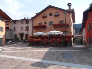 a building with umbrellas and flowers in a courtyard at Albergo Betulla in Onore