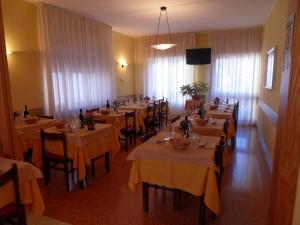 une salle avec des tables et des chaises dans un restaurant dans l'établissement Albergo Betulla, à Onore