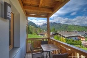 a balcony with a table and chairs and mountains at Residenz an der Burg by Kaprun Rentals in Kaprun