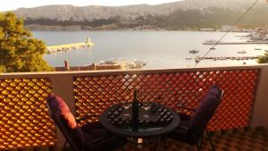 a balcony with a table and chairs and a view of a lake at Apartments Andrea in Baška