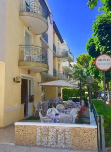 a restaurant with chairs and tables in front of a building at Hotel Monti in Riccione