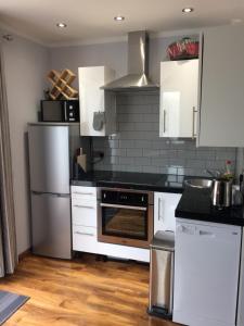 uma cozinha com armários brancos e um forno com placa de fogão em 32a railside em Inverness