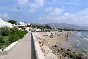 a beach with a bunch of people in the water at Hotel Llorca in Platja de l’Almadrava