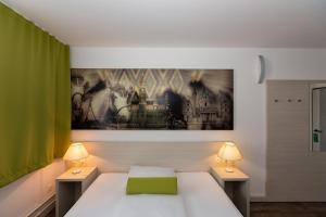 a bedroom with a white bed and two lamps at LifeHotel Vienna Airport in Fischamend Dorf