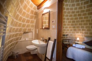 a bathroom with a sink and a toilet in a room at Grandi Trulli Bed & Breakfast in Alberobello
