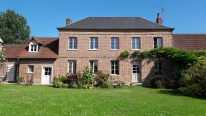 ein altes Backsteinhaus mit großem Hof in der Unterkunft Le Bien-Venant in Domvast