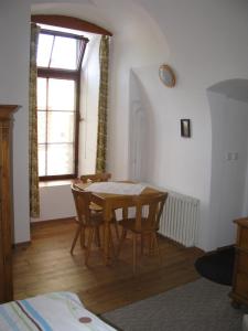 a dining room with a table and chairs and a window at Penzion 102 in Pardubice